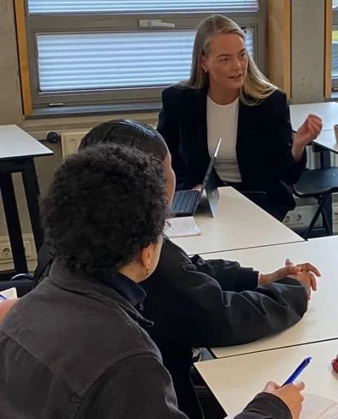 Talking with students at a table during the guest lecture at The Hague University of Applied Sciences
