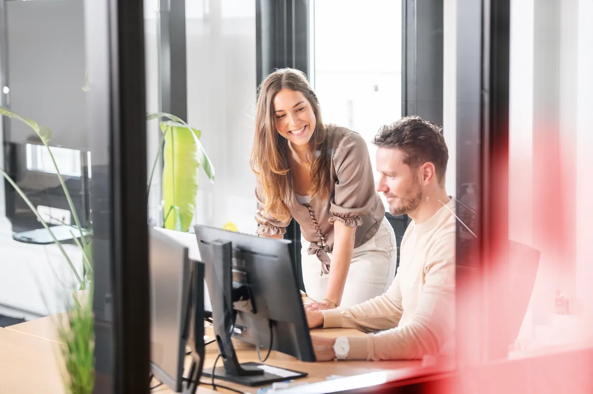 Twee Innovi-collega's werken samen achter een laptop